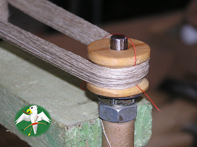 For the lack of a better term I translate what you see here directly as "core spool". For doing rather thick strings core spools with concave cross sections are a nescessity, because the string diameter already effects the lenght of every single strand. A red thread of silk was included to mark the onehundred strand position. If anything goes wrong, one can continue from there.   © Falk 2007