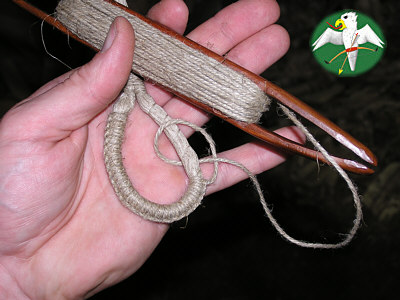 Using the shuttle the serving is layed out the way indicated by the picture; a process known to the Englishmen as 'Cockscombing'. With every turn the direction is changed, forming a row of "knots". Care must be taken that all knots stay in single plane on the outskirts of the loop.   © Falk 2007