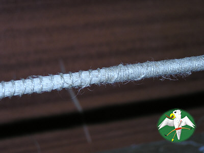 From loops to center-serving a part of the string is served widely. The center-serving starts and ends with about an inch in knotted style to secure it in place. The very center is only served, to keep it true in cross section. The fuzzyness of the coarse linen thread can be (carefully) removed by a soft flame.   © Falk 2007